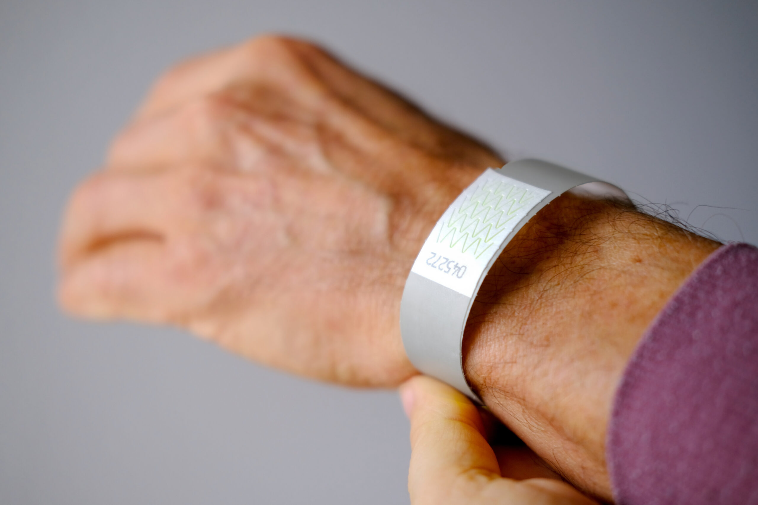 Close-up,Of,Neon,Yellow,Paper,Bracelet,On,The,Male,Arm